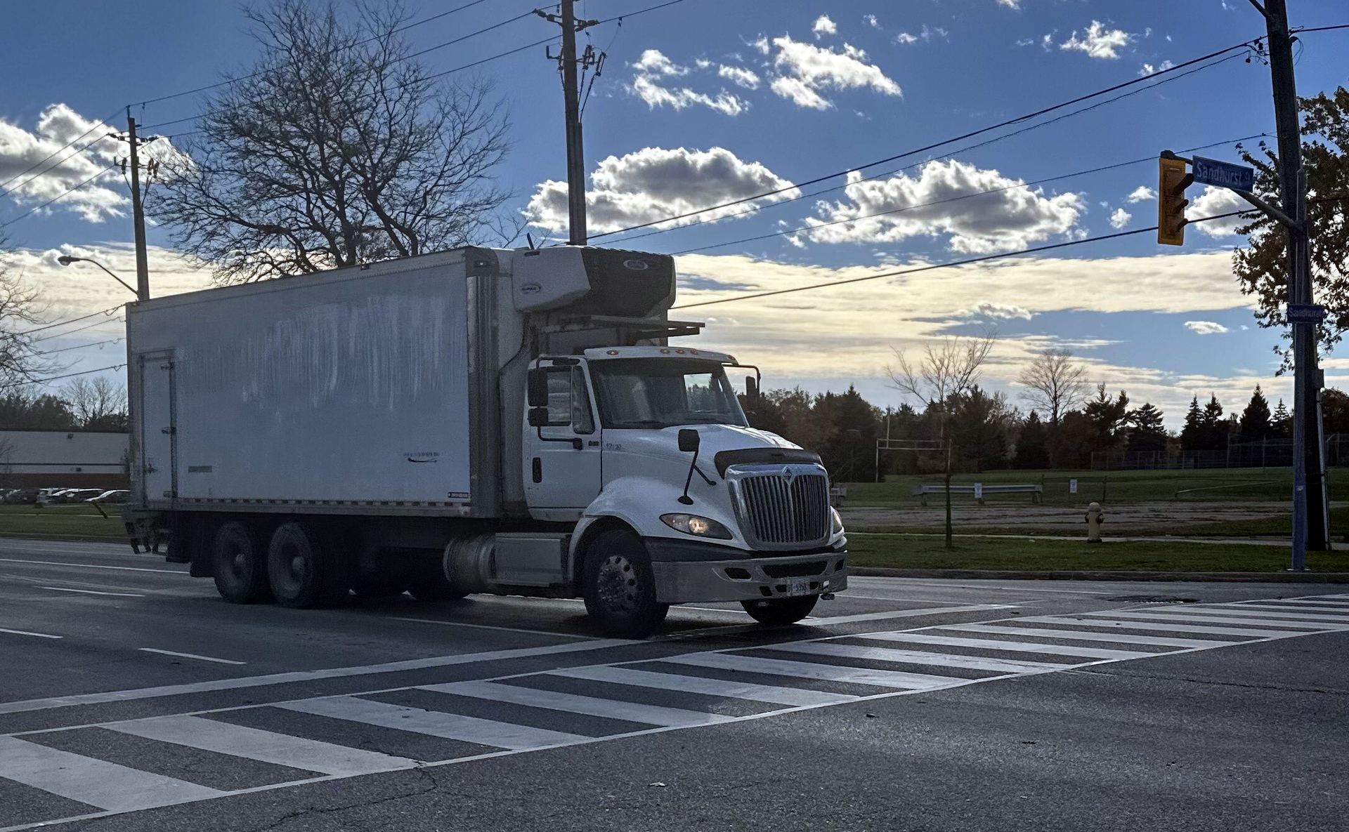 Refrigerated straight truck turning at a suburban intersection